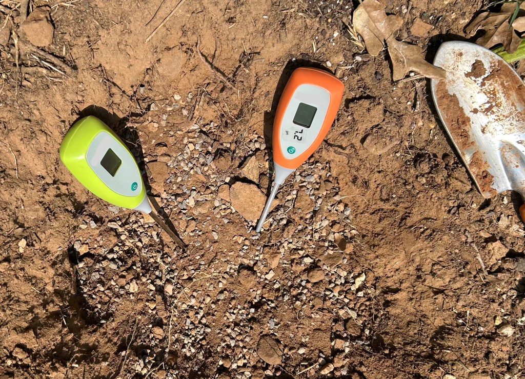 Testing pH and moisture in soil with meters to improve the quality of soil for planting